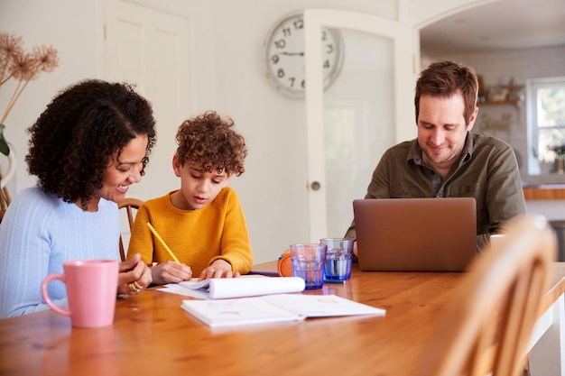 A family sitting at a table, reviewing college financial aid options on a laptop, smiling and pointing at the screen, warm and inviting atmosphere, representing informed decision-making.