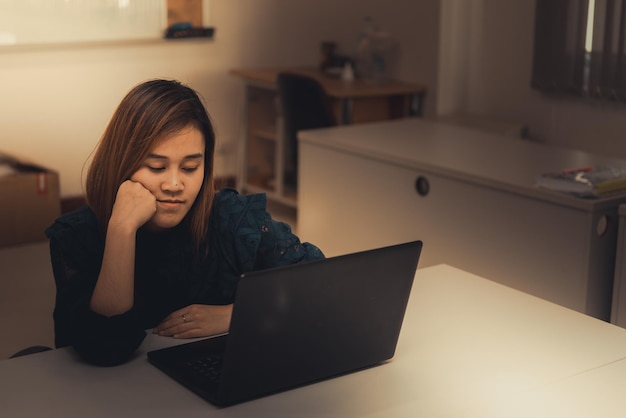 Close-up of a student looking frustrated while sitting in front of a laptop during a virtual class. The lighting is dim, and the student appears tired and disengaged.