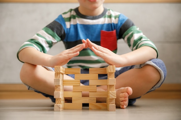 A young child using building blocks to create a tower, showcasing hands-on learning and problem-solving skills. The child is focused and engaged, highlighting the benefits of interactive play in early education.