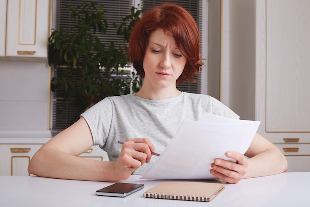 A person reviewing tax documents with a thoughtful expression, symbolizing the preparation needed for the 2025 tax changes.