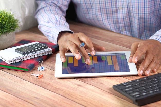 A person calculating the break-even point for refinancing on a spreadsheet. The image includes a calculator, and emphasizes the comparison of costs versus savings.