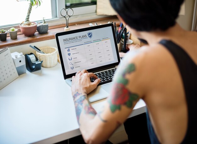 A person sitting at a desk with a laptop, comparing credit card interest rates displayed on multiple browser tabs. The image is well-lit and modern, suggesting a focus on financial planning.