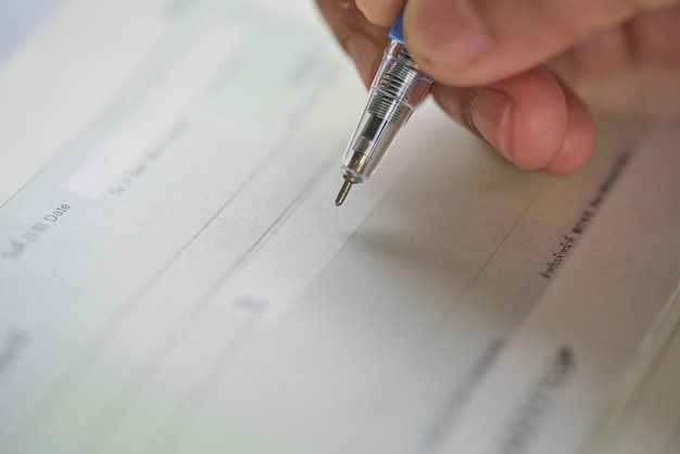 A close-up of a credit report document being reviewed by a person with a pen in hand, highlighting sections related to payment history and credit utilization.