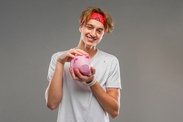A split image showing a teen cheerfully putting money in a piggy bank on one side, and a different teen looking stressed while surrounded by credit card bills on the other side, highlighting the impact of financial literacy.
