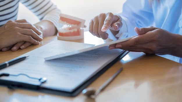 Close-up of a person reviewing documents related to vision and dental insurance plans on a tablet. The setting suggests a home office environment, conveying the research and planning involved in benefit selection.