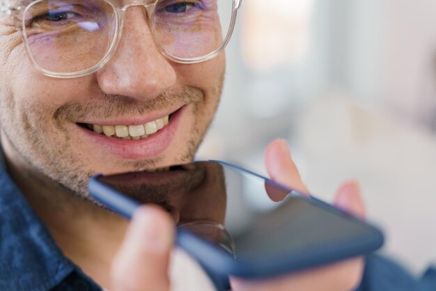 A person wearing glasses checks dental insurance coverage details on a smartphone, with a dentist chair visible in the blurry background. The image suggests convenient access to information and informed decision-making.