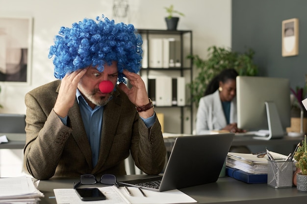 An employee looking stressed at their desk, contrasting with a thought bubble showing relaxation and balance, illustrating the benefits of an EAP in managing workplace stress.