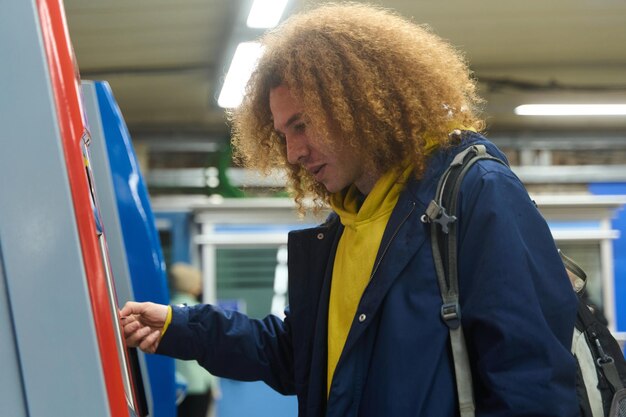 A person filling up a benefits card at a kiosk in a train station, highlighting the convenience and accessibility of commuter benefits programs.