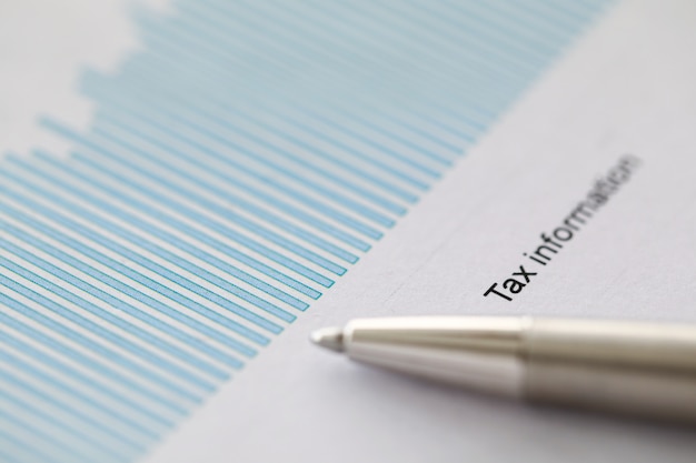 A close-up of a tax form with a pen resting on the document. The form is partially filled out, and financial calculations are visible.