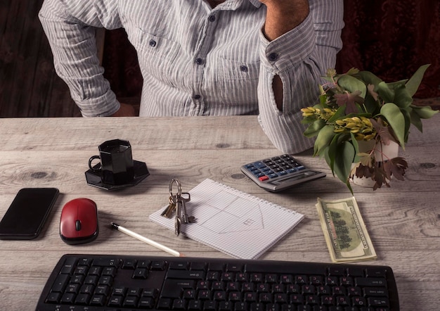 A person sitting at a table, using a laptop and a calculator, planning their business and personal finances side-by-side. The scene emphasizes the integration of both aspects in financial planning.