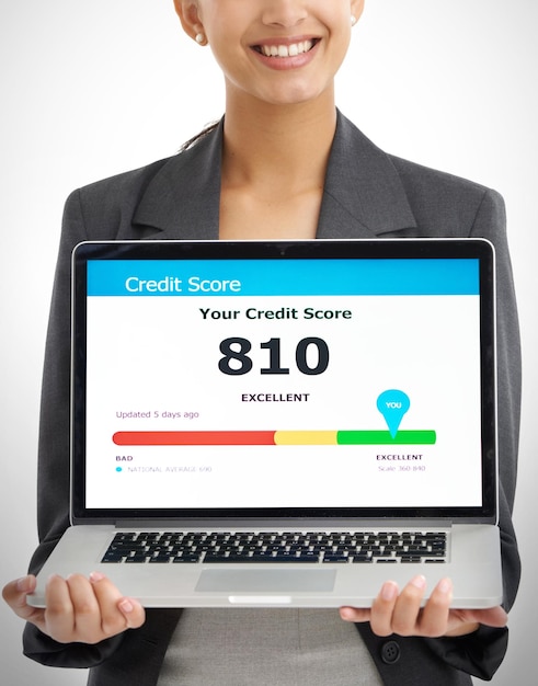 A person using a laptop to check their credit report online. The screen shows a credit report with key information highlighted.