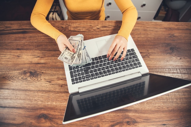 A person using a laptop to transfer money into a high-yield savings account, symbolizing the ease and accessibility of online banking for emergency funds.