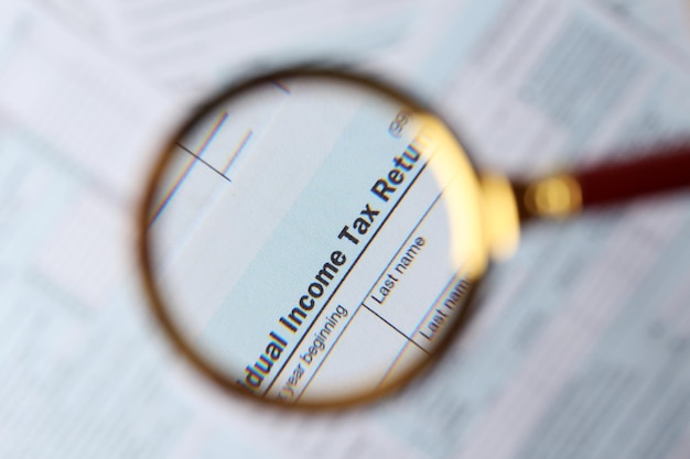 A visual representation of a tax form with a magnifying glass hovering over the section for IRA deductions, highlighting the tax benefits of contributing to a Traditional IRA.