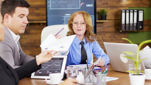 A financial advisor meeting with a female client in a well-lit office. They are reviewing investment portfolios and discussing financial goals, with a focus on building a secure future.