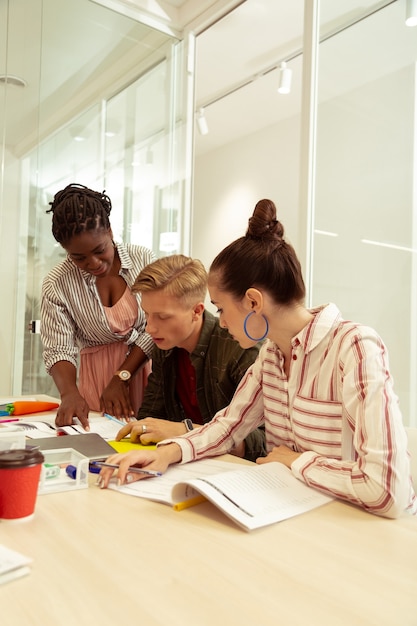 Teachers collaborating in a brightly lit workspace, sharing ideas and resources. The image emphasizes teamwork, professional development, and the importance of a supportive work environment for educators. The scene is uplifting and positive, highlighting the value of collaboration and continuous learning in the teaching profession.