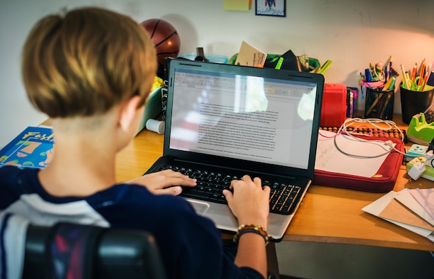 Close up of a student completing the FAFSA form on a laptop, with a sense of concentration and determination. The background shows a supportive parent or guardian.