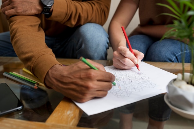 A close-up shot of a diverse group of hands holding pencils over standardized test booklets. The hands are different skin tones, representing a mix of ethnicities. The test booklets are partially visible, showing multiple choice questions. The overall image conveys a sense of focus and determination, but also a hint of anxiety.