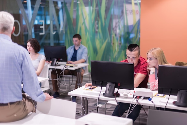 A high school science classroom with students using computers for coding and data analysis. The students are working individually but occasionally collaborate with their neighbors. The atmosphere is focused but relaxed, emphasizing the integration of technology in modern STEM education.