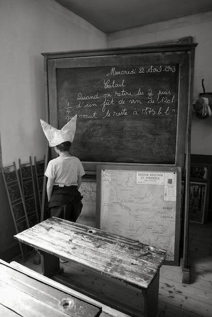 A vintage photograph from the early 20th century showing a classroom of students diligently taking a standardized test with paper and pencils, reflecting a traditional testing environment.