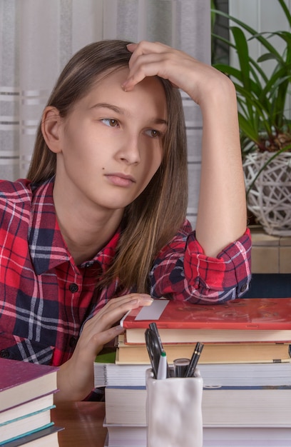 A close-up shot of a stressed high school student sitting at a desk, surrounded by textbooks and notes. The student appears overwhelmed and anxious, with a visible expression of frustration and exhaustion.