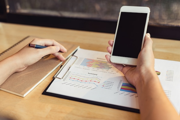 A person using a budgeting app on their smartphone, with graphs and charts illustrating their spending habits and progress toward their financial goals.