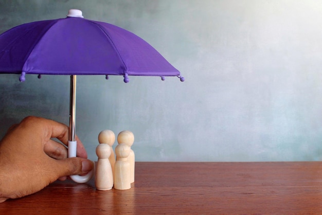 A family standing together under an umbrella, symbolizing insurance protection against various risks like health issues, job loss, and accidents.