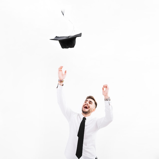 A person confidently throwing a graduation cap in the air, symbolizing the achievement of higher education, with a faint overlay of financial charts in the background, representing the financial planning required post-graduation.