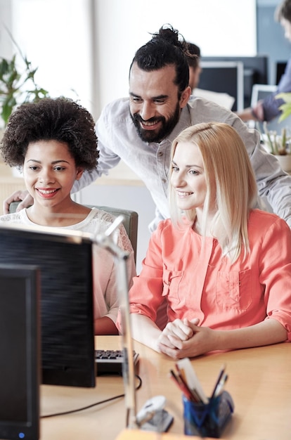 A team of employees collaborating in an office, smiling and engaged in their work, representing improved productivity and engagement.