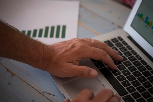 A close-up shot focusing on hands typing on a laptop, with a spreadsheet displaying benefit options and cost calculations visible in the background. The scene is set in a well-lit office, conveying the detailed analysis needed for strategic adjustments.