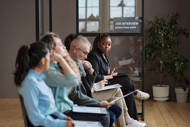 A diverse group of employees sitting in a conference room, attentively listening to a presentation on employee benefits compliance. The presenter is pointing to a slide that highlights key compliance requirements. The atmosphere is professional and engaging.