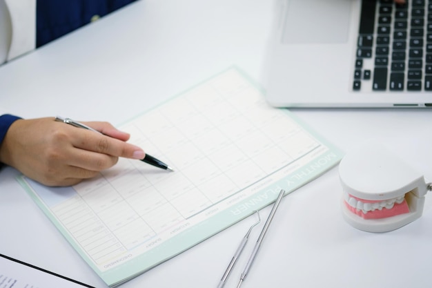 A close-up shot of a benefits enrollment form, highlighting sections related to vision and dental insurance options. A hand is seen carefully filling out the form with a pen.