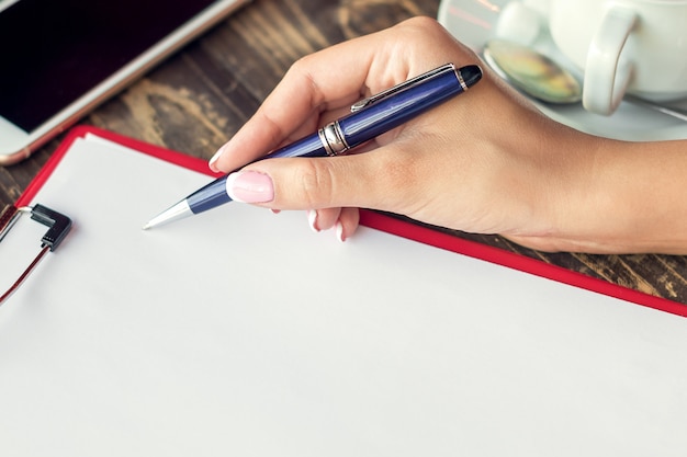 A close-up shot of a person's hands carefully signing a legal document, emphasizing the importance and formality of creating a will. A pen rests on the document, and the background is softly blurred.