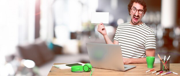 A person cutting a credit card in half while sitting at a desk with a laptop, symbolizing debt reduction and financial freedom.