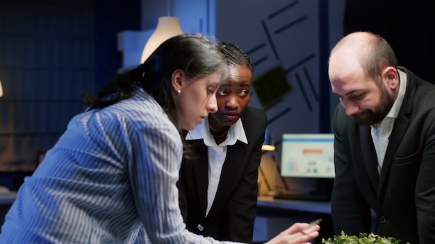 A diverse group of investors discussing financial charts and graphs in a modern office setting. The scene emphasizes collaboration and data-driven decision-making.