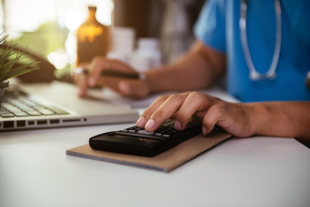 A person using a calculator and reviewing a health insurance statement with a highlighted section showing the coinsurance percentage, emphasizing cost-sharing in healthcare.